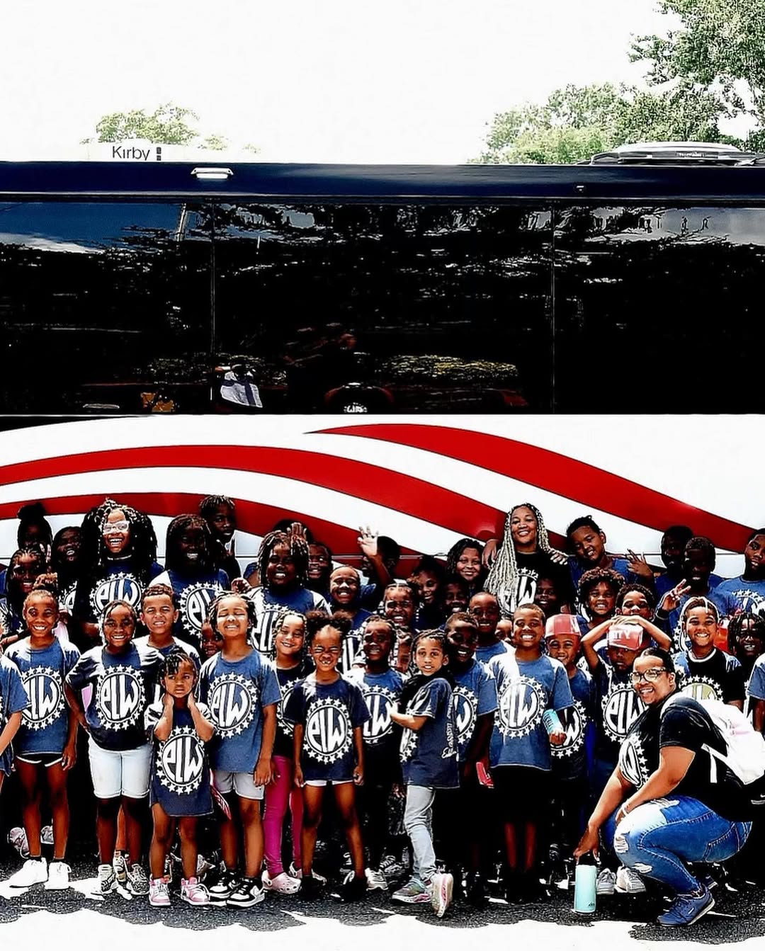ELW youth in matching shirts gathered in front of a charter bus for a program outing